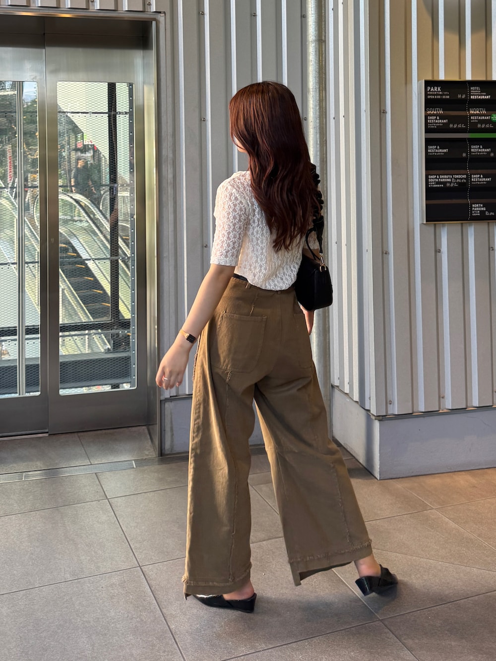 ブラック系のパンプス、ブラック系のハンドバッグ、ホワイト系のTシャツ/カットソーを着用したレディースの夏コーディネートの4枚目の写真