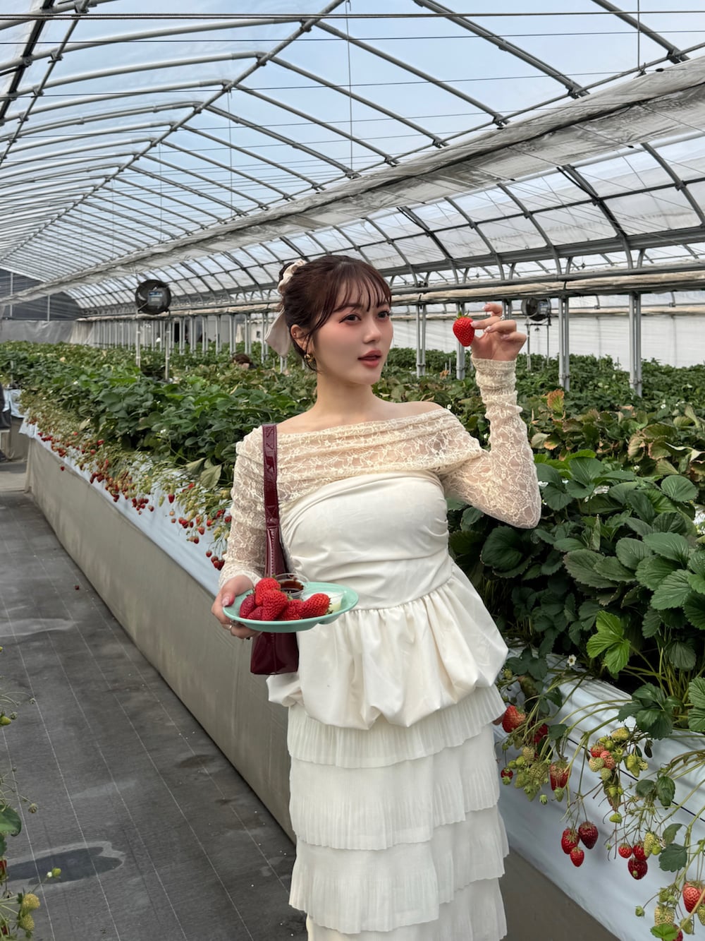 ホワイト系のTシャツ/カットソー、レッド系のハンドバッグ、ベージュ系のスカートを着用したレディースの春コーディネートの4枚目の写真