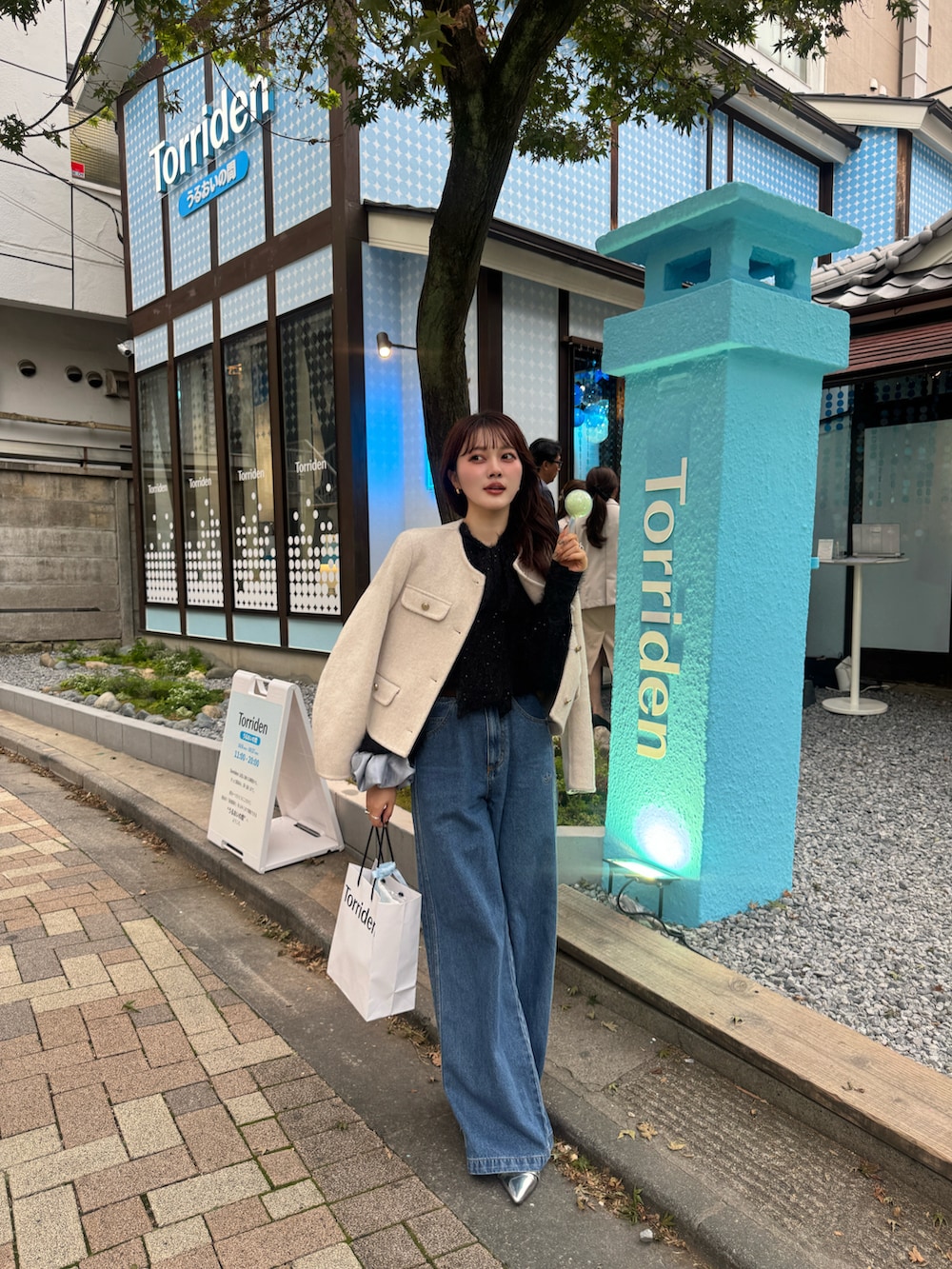 ブルー系のデニムパンツ、シルバー系のパンプス、ブラック系のシャツ/ブラウスを着用したレディースの秋コーディネートの4枚目の写真