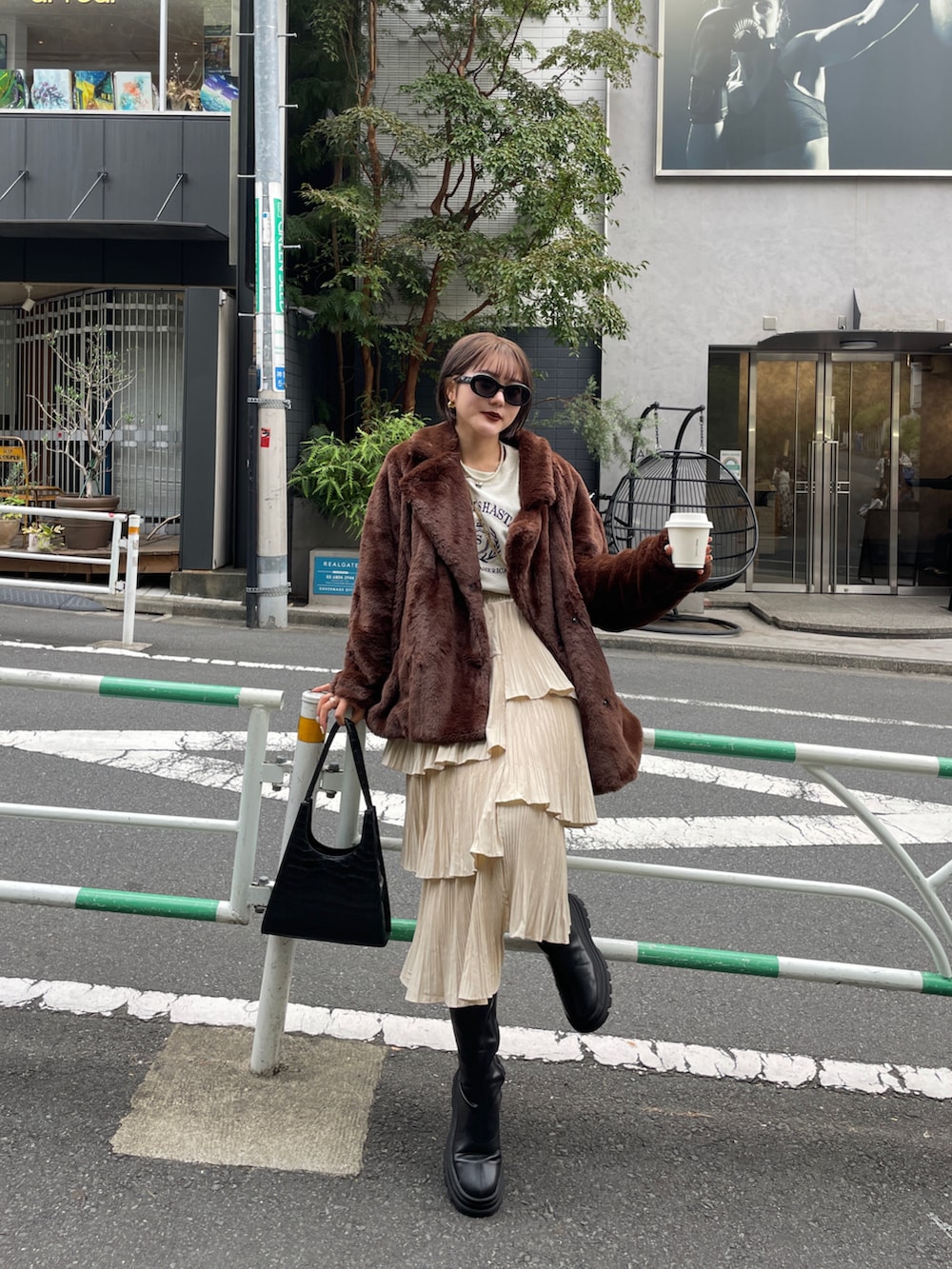 ブラック系のブーツ、ブラウン系のその他アウターを着用したレディースの春コーディネートの3枚目の写真