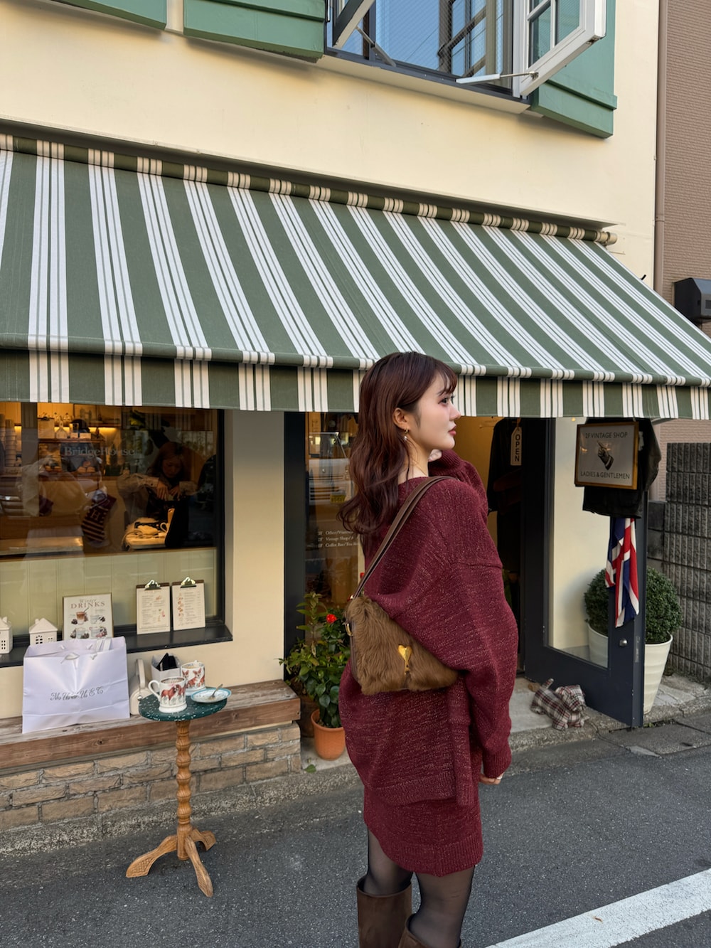 レッド系のアンサンブル、ブラウン系のブーツを着用したレディースの冬コーディネートの4枚目の写真