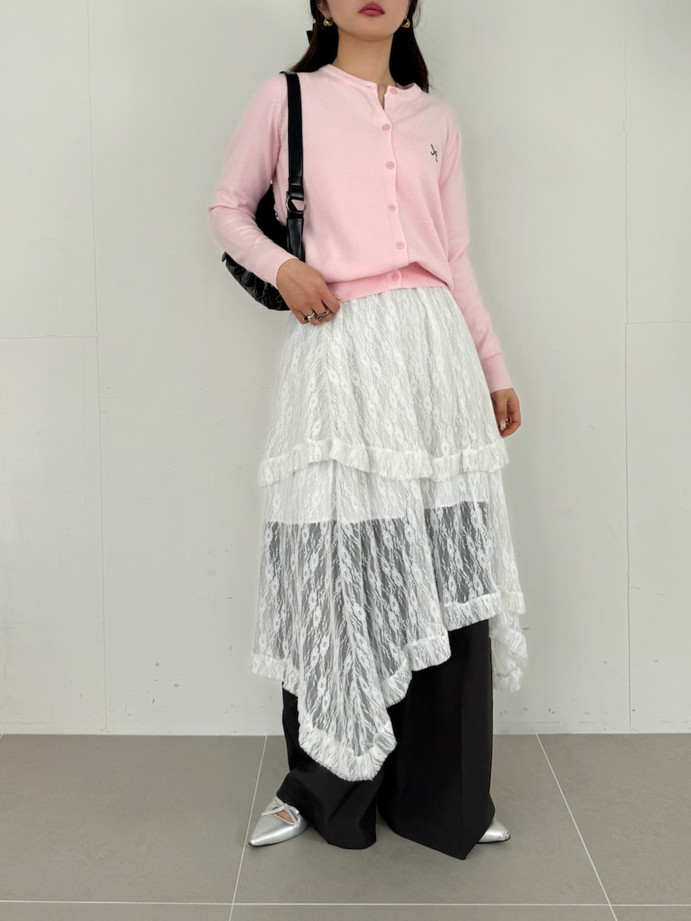 ホワイト系のスカート、ピンク系のカーディガン/ボレロ、ブラウン系のショルダーバッグを着用したレディースの春コーディネートの2枚目の写真