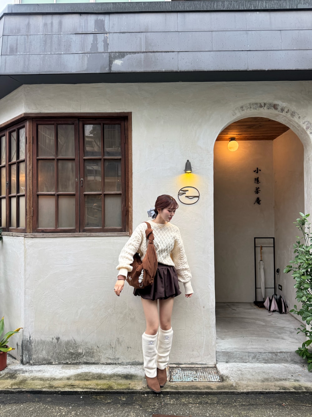 ブラウン系のブーツ、ブラウン系のスカート、ホワイト系のニット/セーターを着用したレディースの冬コーディネートの4枚目の写真