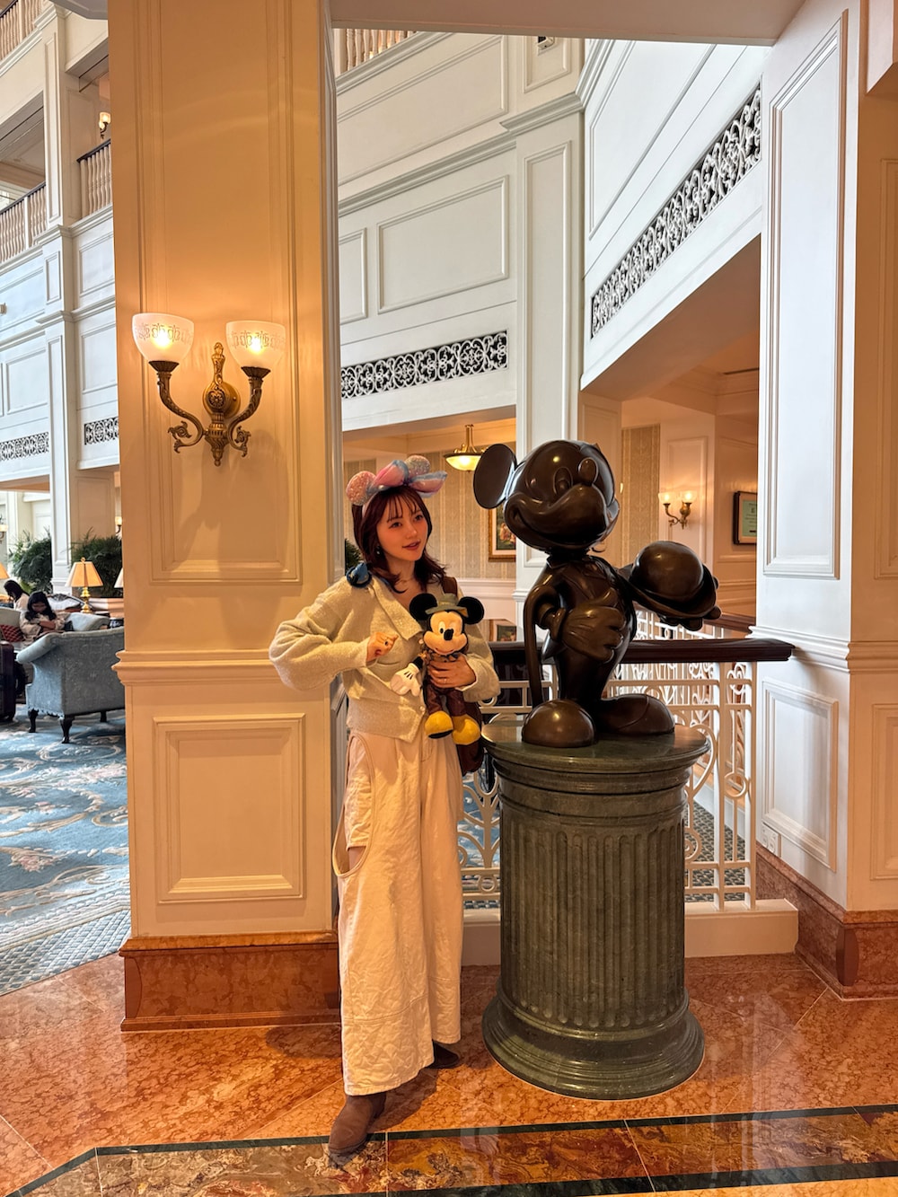 ホワイト系のカーディガン/ボレロ、ホワイト系のデニムパンツ、ブラウン系のブーツを着用したレディースの冬コーディネートの5枚目の写真