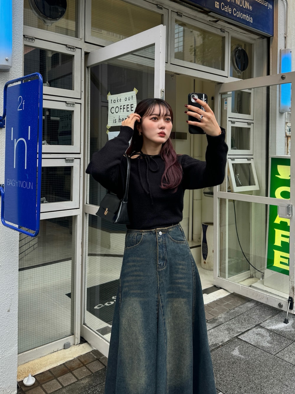 ブラック系のハンドバッグ、ブラック系のブーツを着用したレディースの秋コーディネートの3枚目の写真