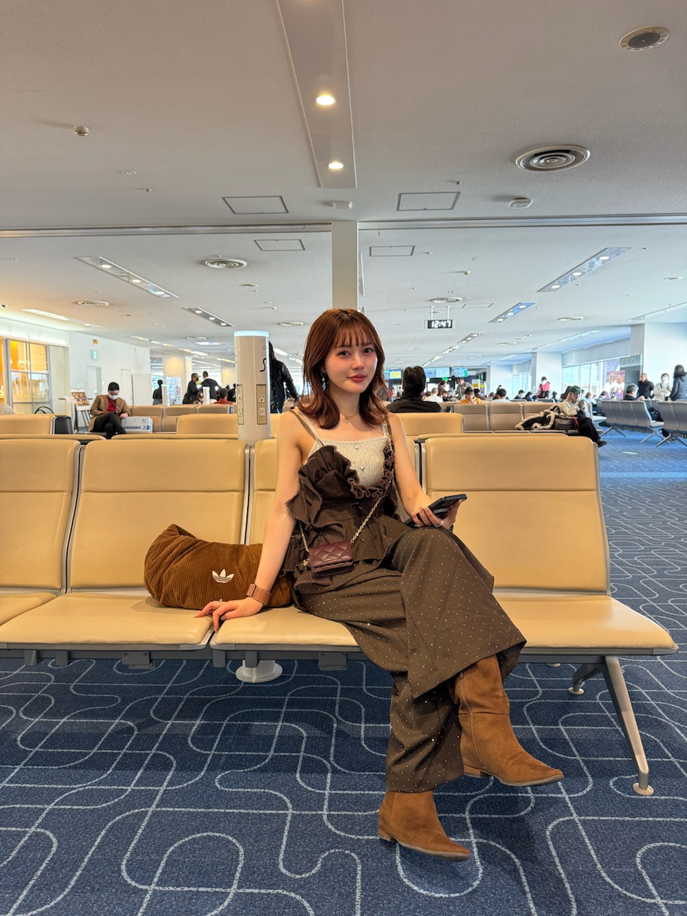 ブラウン系のその他パンツ、ブラウン系のブーツ、ホワイト系のカーディガン/ボレロを着用したレディースの冬コーディネートの5枚目の写真