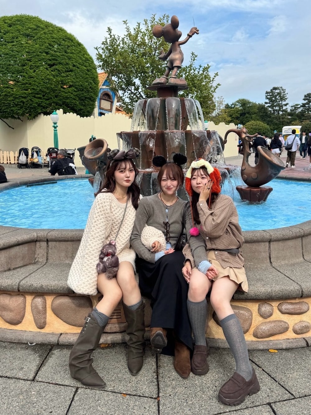 ピンク系のニット/セーター、ブラウン系のブーツ、ブラック系のスカートを着用したレディースの秋コーディネートの2枚目の写真