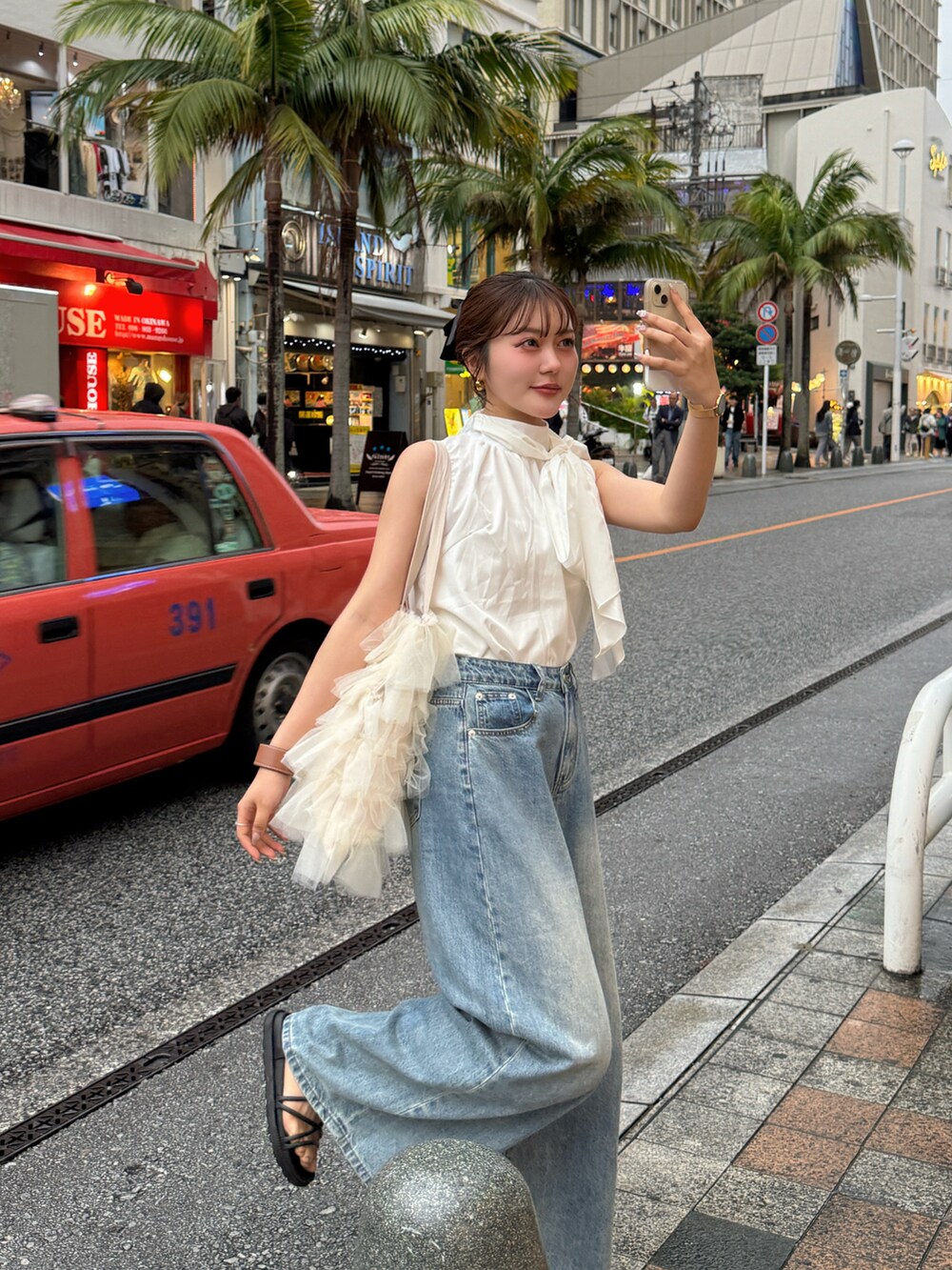 ブラック系のトートバッグ、ホワイト系のトップスを着用したレディースの春コーディネートの2枚目の写真