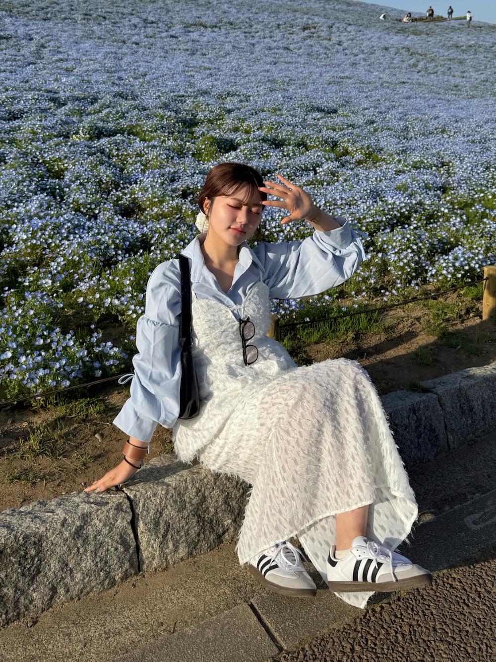 ホワイト系のTシャツ/カットソー、ホワイト系のスカート、ホワイト系のスニーカーを着用したレディースの春コーディネートの5枚目の写真