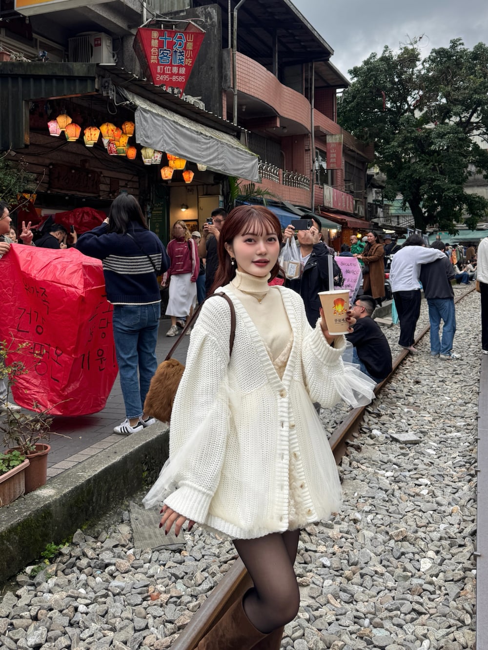 ブラウン系のブーツ、ホワイト系のカーディガン/ボレロを着用したレディースの冬コーディネートの4枚目の写真