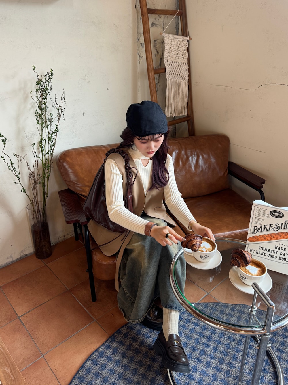 ブルー系のデニムスカート、ベージュ系のニット/セーター、ベージュ系のベストを着用したレディースの秋コーディネートの2枚目の写真