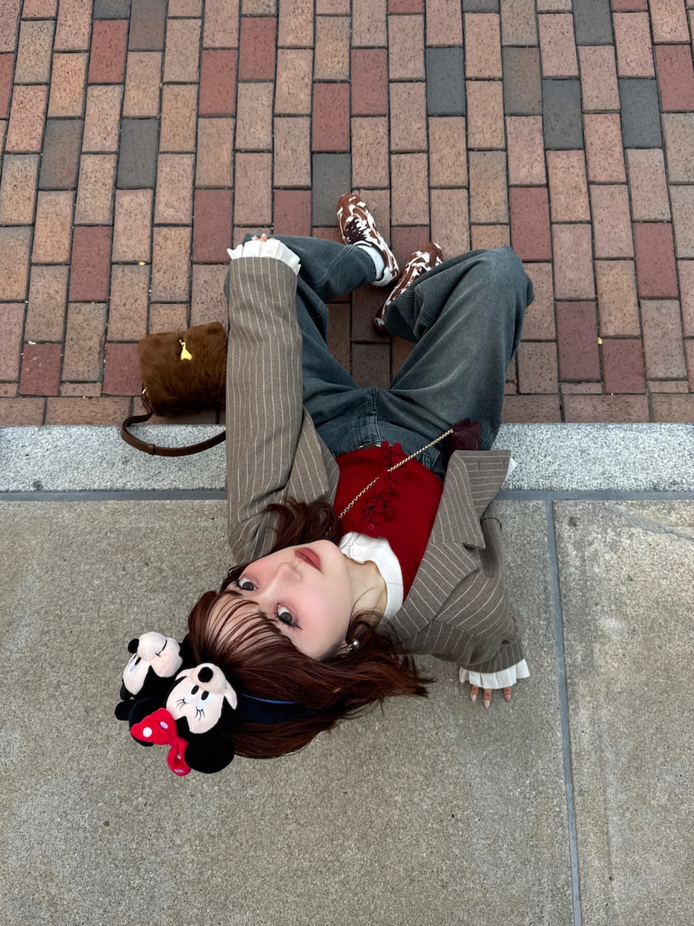 ブラウン系のテーラードジャケット、ブルー系のデニムパンツ、ブラウン系のスニーカーを着用したレディースの冬コーディネートの3枚目の写真