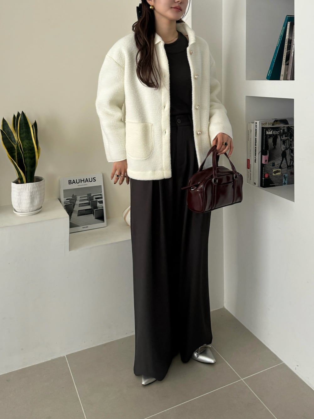 ホワイト系のブルゾンを着用したレディースの冬コーディネートの2枚目の写真