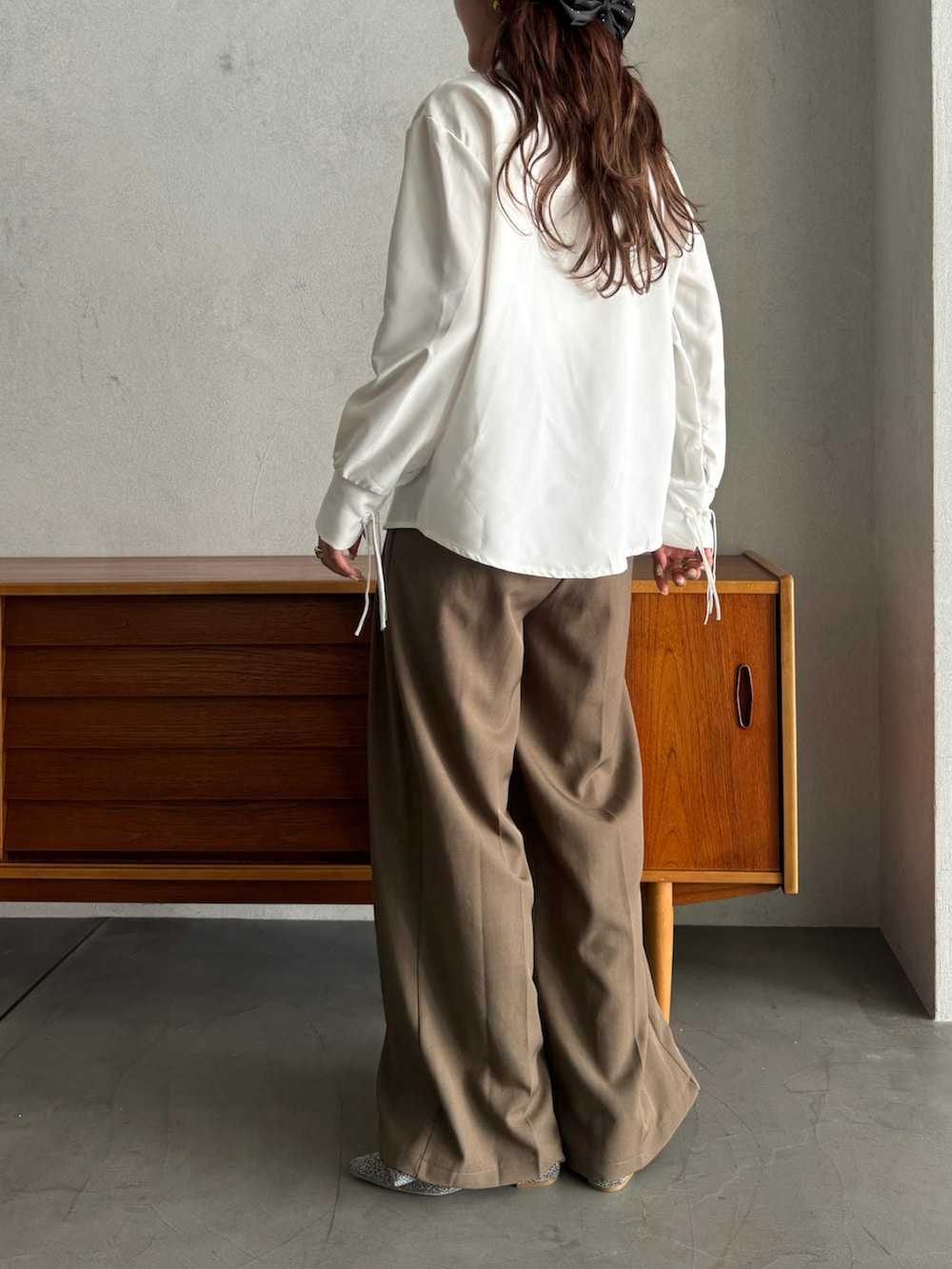 シルバー系のパンプス、ベージュ系のスラックス、ホワイト系のシャツ/ブラウスを着用したレディースの春コーディネートの3枚目の写真