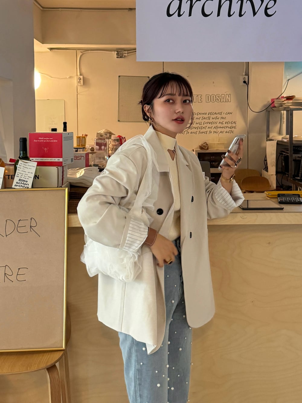 グレー系のTシャツ/カットソー、ホワイト系のハンドバッグを着用したレディースの冬コーディネートの2枚目の写真