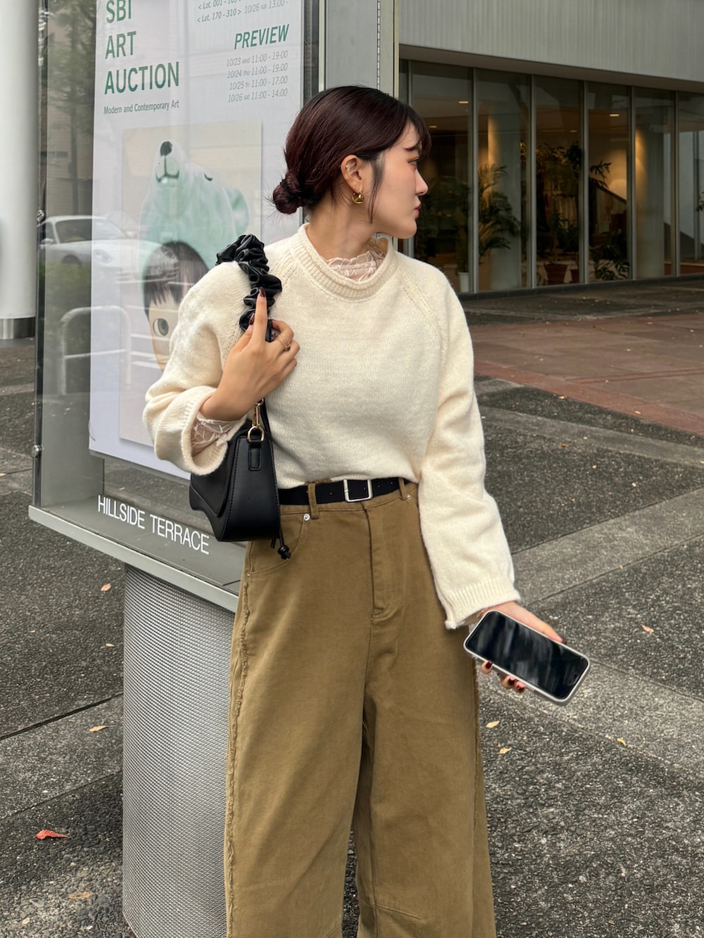 ブラウン系のハンドバッグ、ホワイト系のニット/セーターを着用したレディースの秋コーディネートの3枚目の写真
