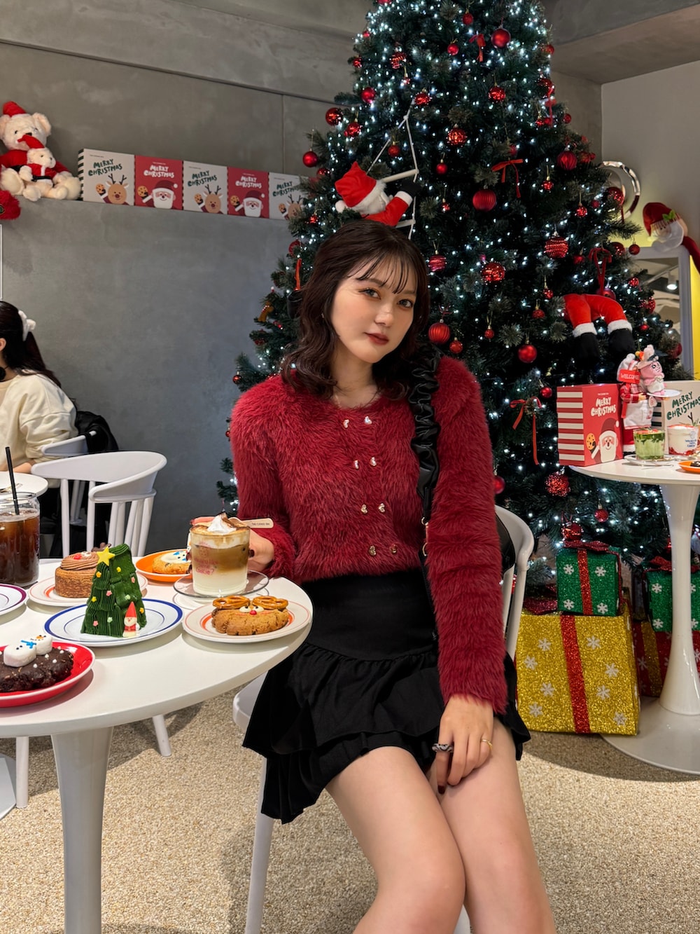 レッド系のカーディガン/ボレロ、ブラウン系のハンドバッグを着用したレディースの秋コーディネートの3枚目の写真