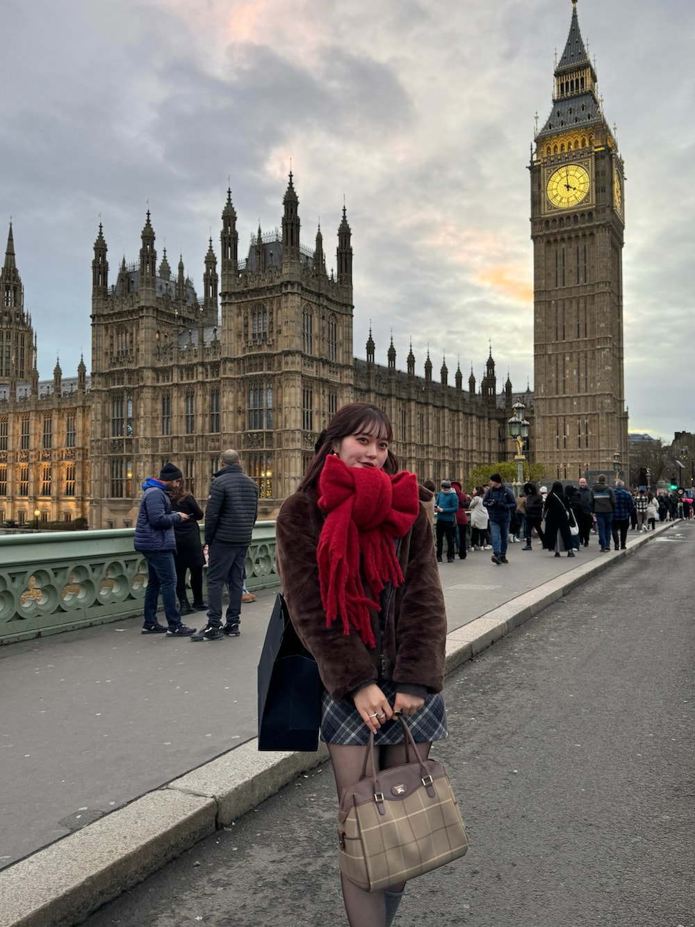 ブラック系のスカート、グリーン系のブルゾン、レッド系のマフラーを着用したレディースの冬コーディネートの3枚目の写真