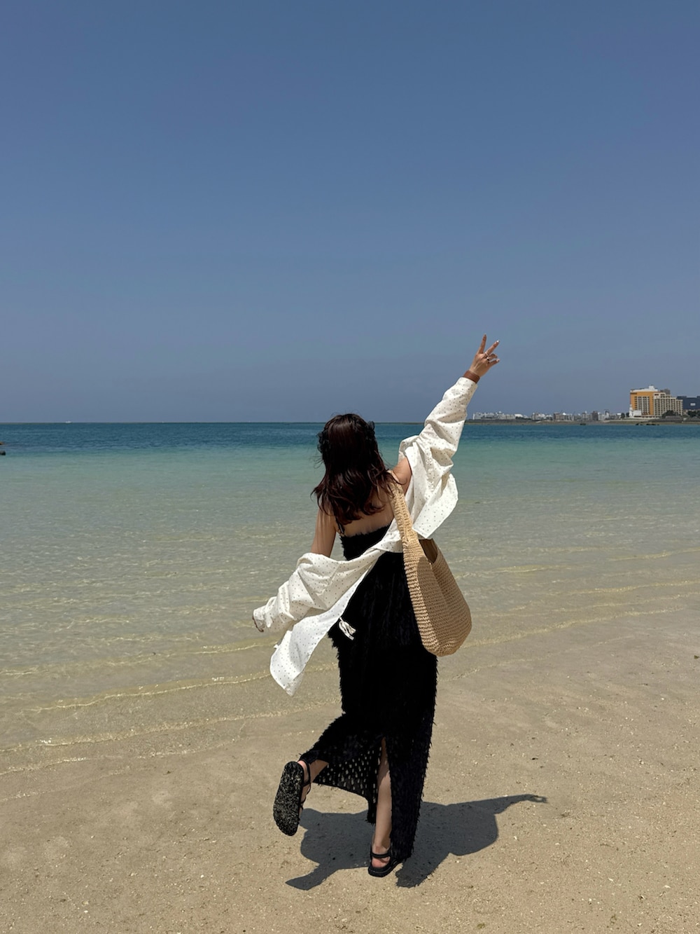 ブラック系のスカート、ブラック系のTシャツ/カットソー、ホワイト系のシャツ/ブラウスを着用したレディースの春コーディネートの3枚目の写真