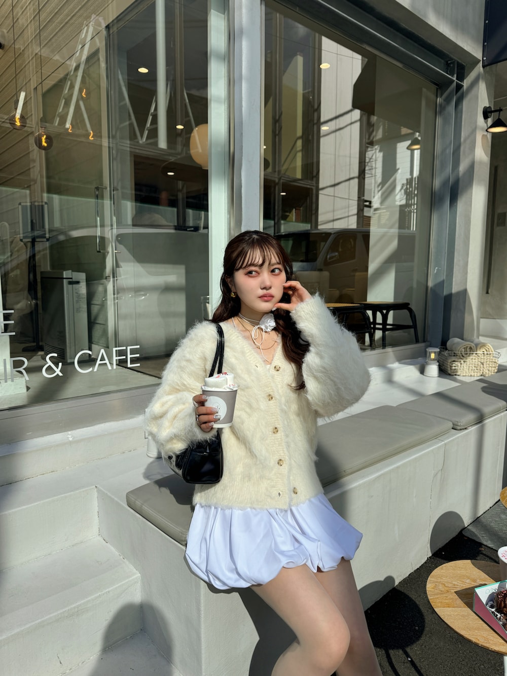 ホワイト系のスカート、ベージュ系のカーディガン/ボレロを着用したレディースの冬コーディネートの4枚目の写真