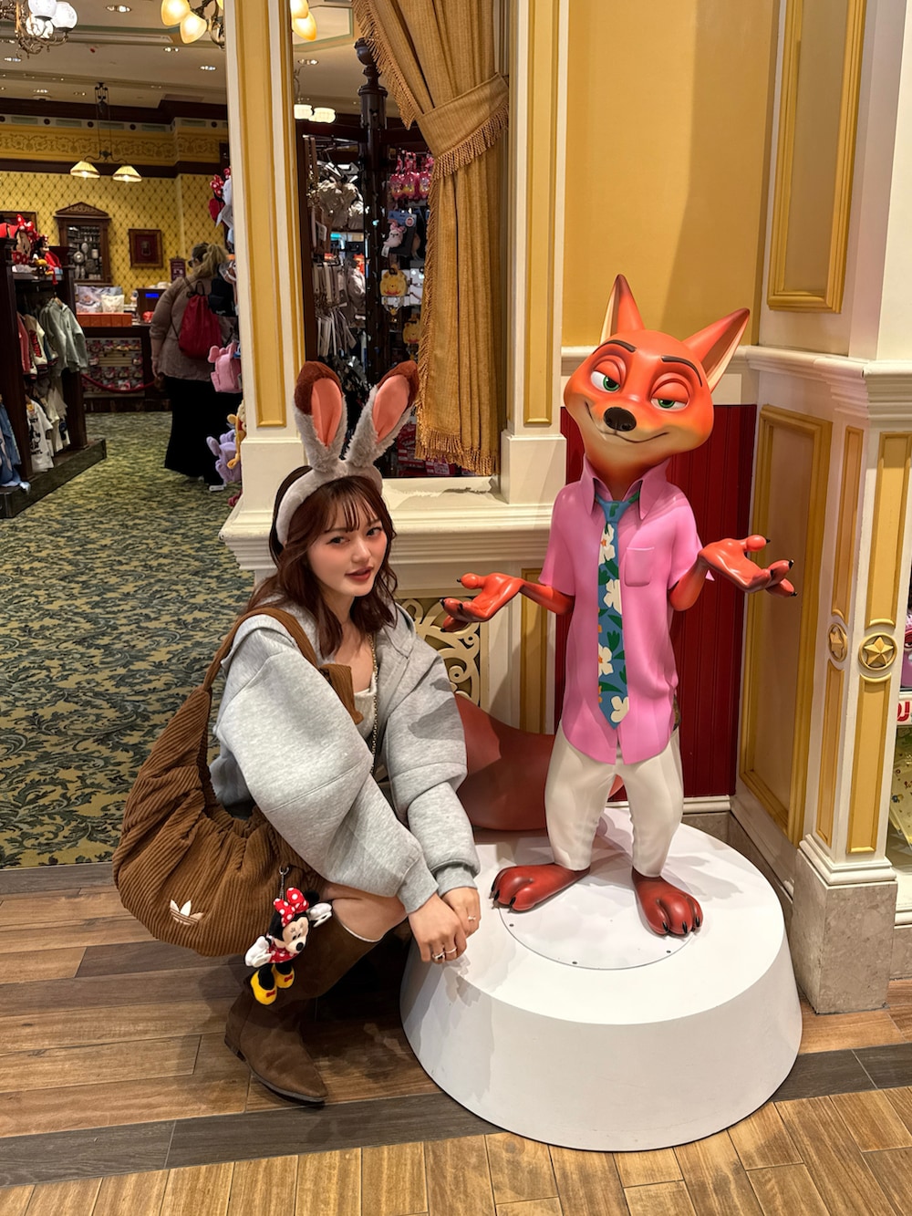 グレー系のパーカー、グレー系のスカート、ブラウン系のブーツを着用したレディースの冬コーディネートの2枚目の写真