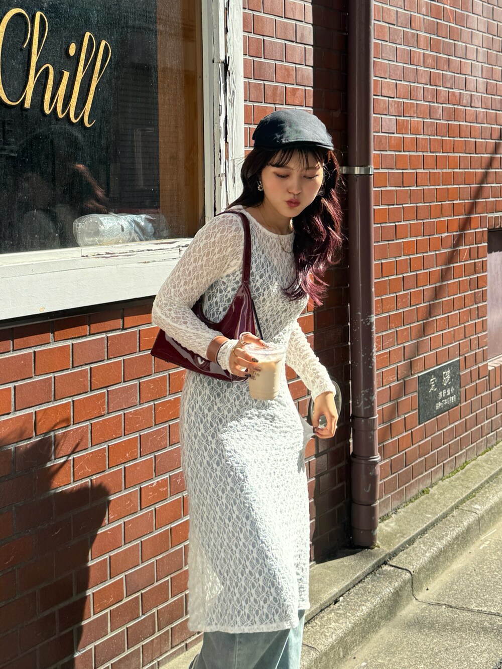 ベージュ系のワンピース、レッド系のハンドバッグ、ベージュ系のスニーカーを着用したレディースの秋コーディネートの4枚目の写真