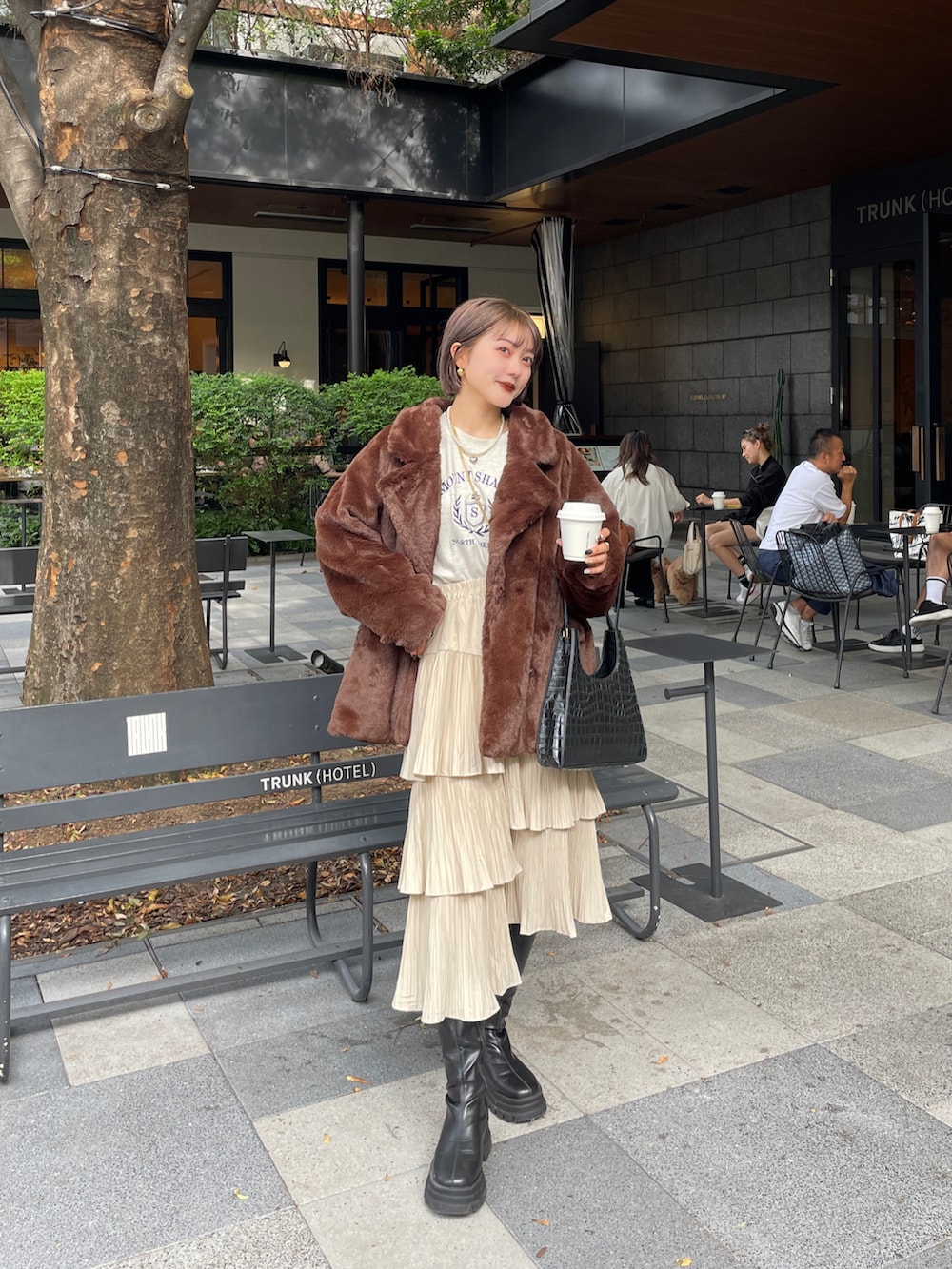 ブラック系のブーツ、ブラウン系のその他アウターを着用したレディースの春コーディネートの4枚目の写真