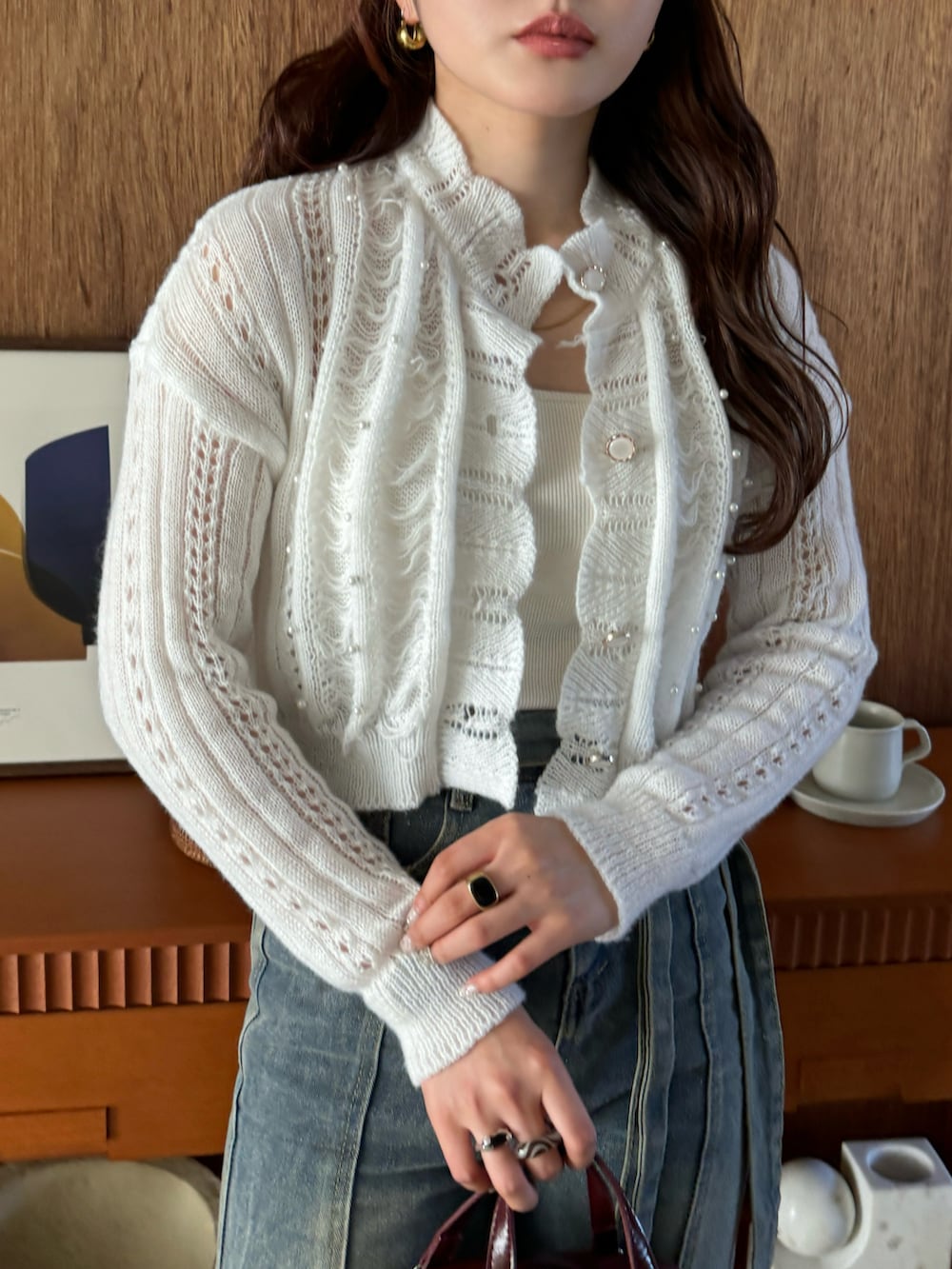 ブルー系のデニムパンツ、ホワイト系のカーディガン/ボレロを着用したレディースの冬コーディネートの3枚目の写真