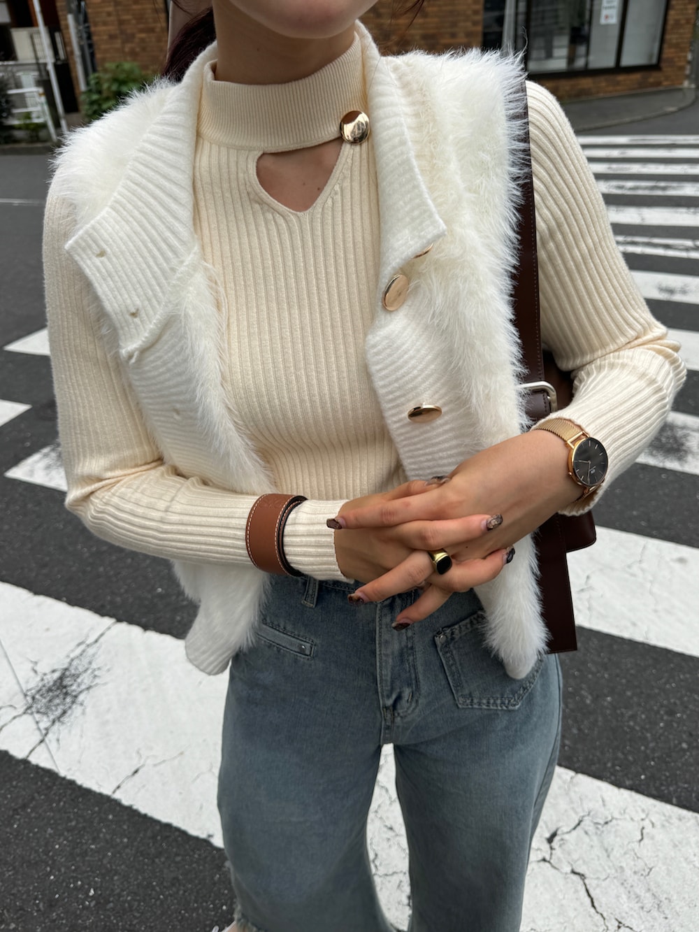 ベージュ系のニット/セーター、ベージュ系のベストを着用したレディースの秋コーディネートの4枚目の写真