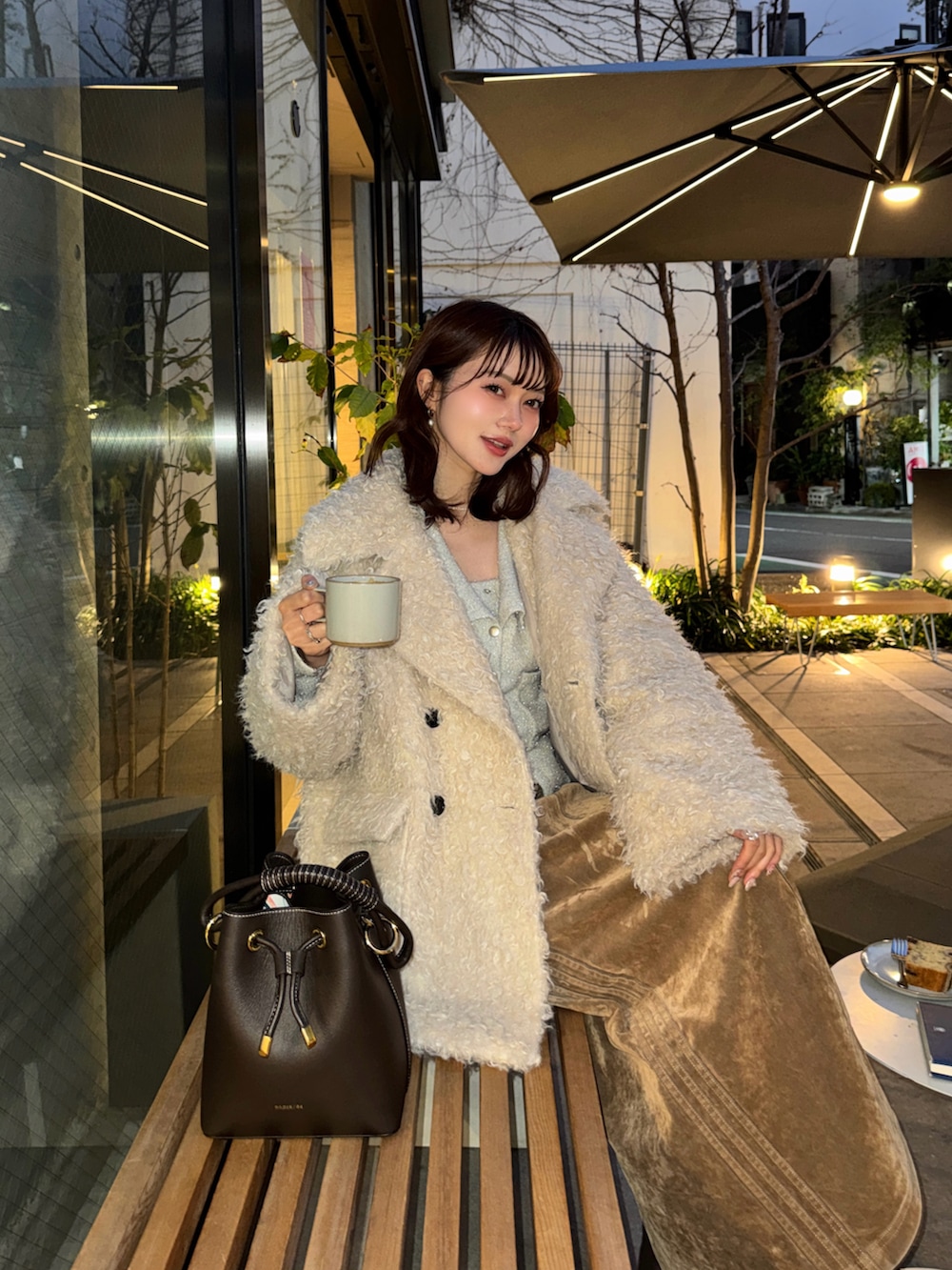 ホワイト系のその他アウター、ホワイト系のカーディガン/ボレロ、ブラウン系のブーツを着用したレディースの冬コーディネートの3枚目の写真