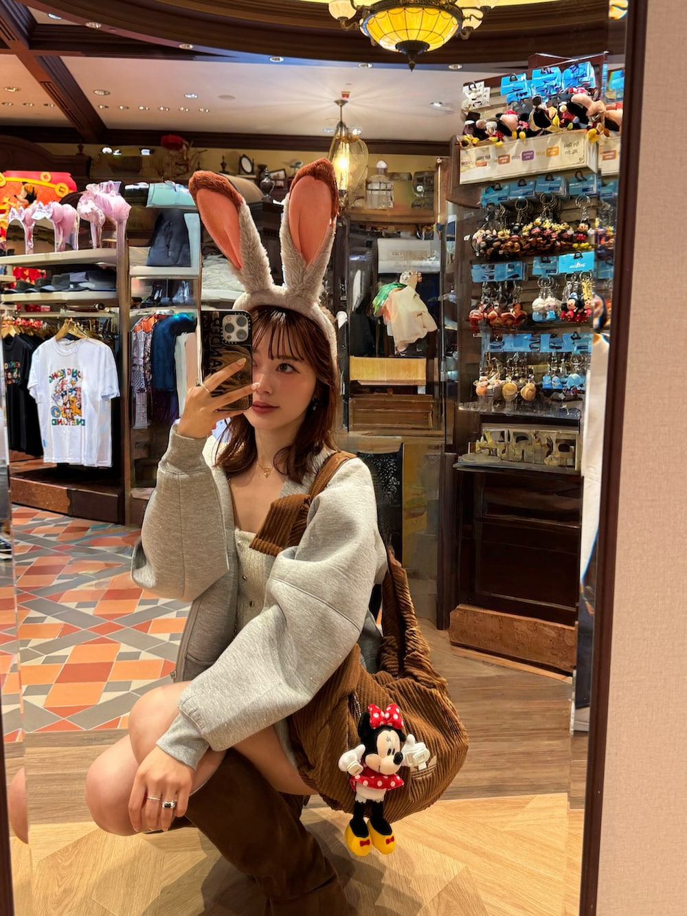 グレー系のパーカー、グレー系のスカート、ブラウン系のブーツを着用したレディースの冬コーディネートの4枚目の写真