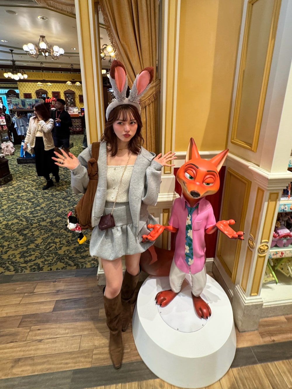 グレー系のパーカー、グレー系のスカート、ブラウン系のブーツを着用したレディースの冬コーディネートの5枚目の写真