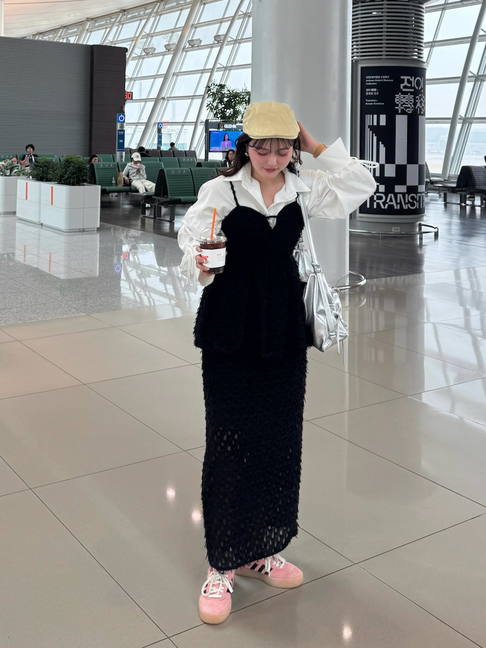 ブラック系のスカート、ブラック系のTシャツ/カットソー、ホワイト系のシャツ/ブラウスを着用したレディースの春コーディネートの2枚目の写真