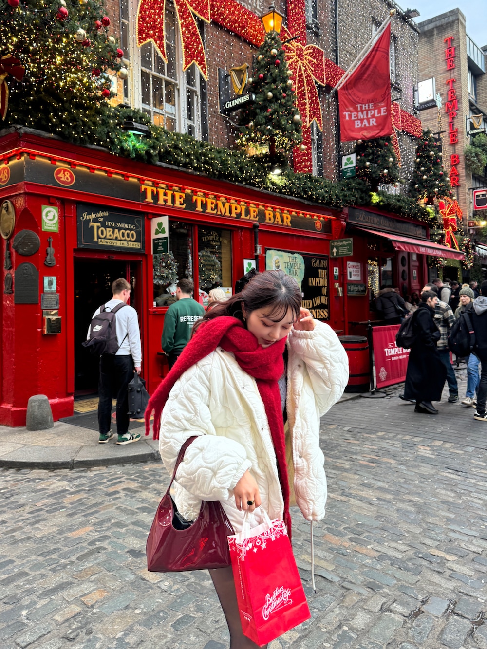 ホワイト系のジャケット/アウター、イエロー系のブーツ、レッド系のハンドバッグを着用したレディースの冬コーディネートの4枚目の写真