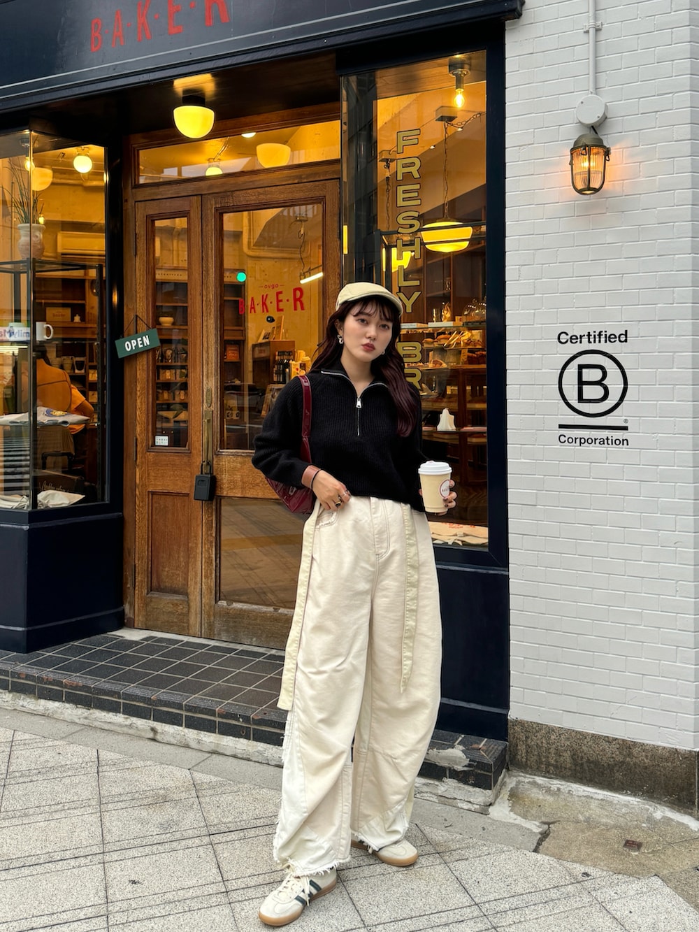 ブラック系のニット/セーター、ホワイト系のデニムパンツ、ベージュ系のスニーカーを着用したレディースの秋コーディネートの4枚目の写真