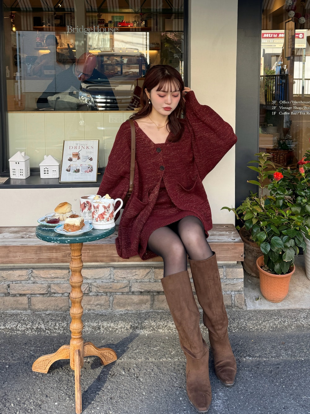 レッド系のアンサンブル、ブラウン系のブーツを着用したレディースの冬コーディネートの3枚目の写真