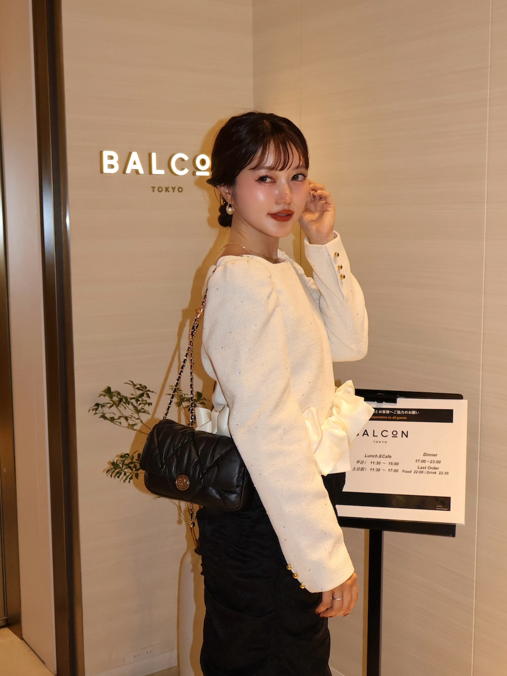 ブラック系のパンプス、ホワイト系のシャツ/ブラウス、ブラック系のスカートを着用したレディースの夏コーディネートの2枚目の写真