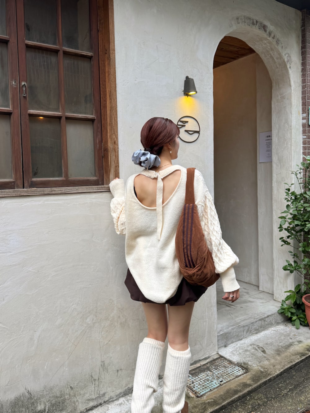 ブラウン系のブーツ、ブラウン系のスカート、ホワイト系のニット/セーターを着用したレディースの冬コーディネートの3枚目の写真