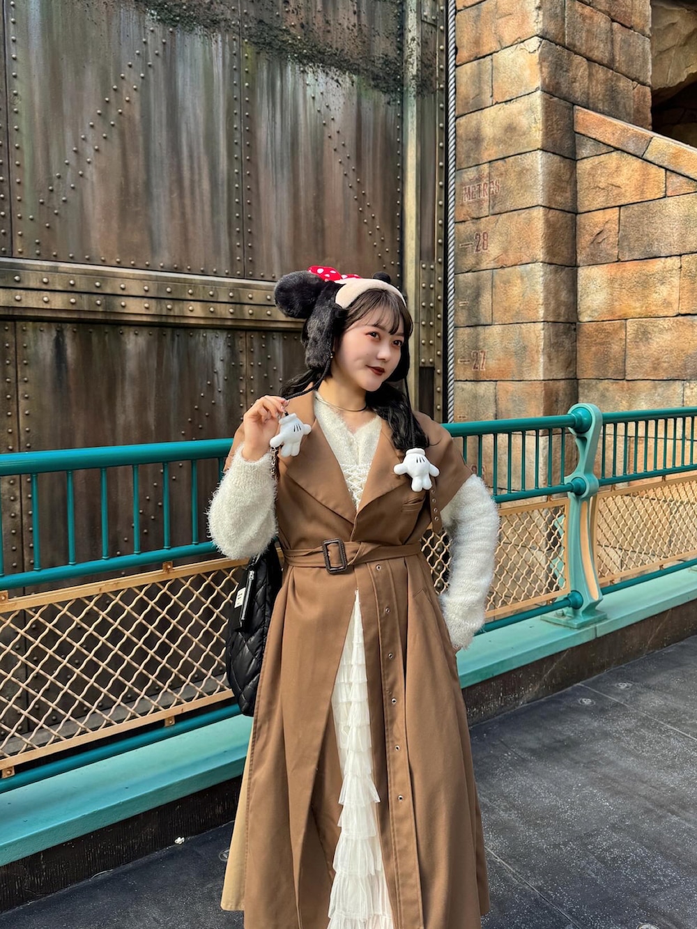 ブラウン系のトレンチコート、ホワイト系のその他トップス、ブラック系のブーツを着用したレディースの冬コーディネートの2枚目の写真