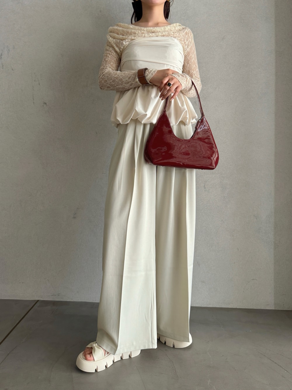 レッド系のハンドバッグ、ホワイト系のスラックス、ホワイト系のシャツ/ブラウスを着用したレディースの春コーディネートの2枚目の写真
