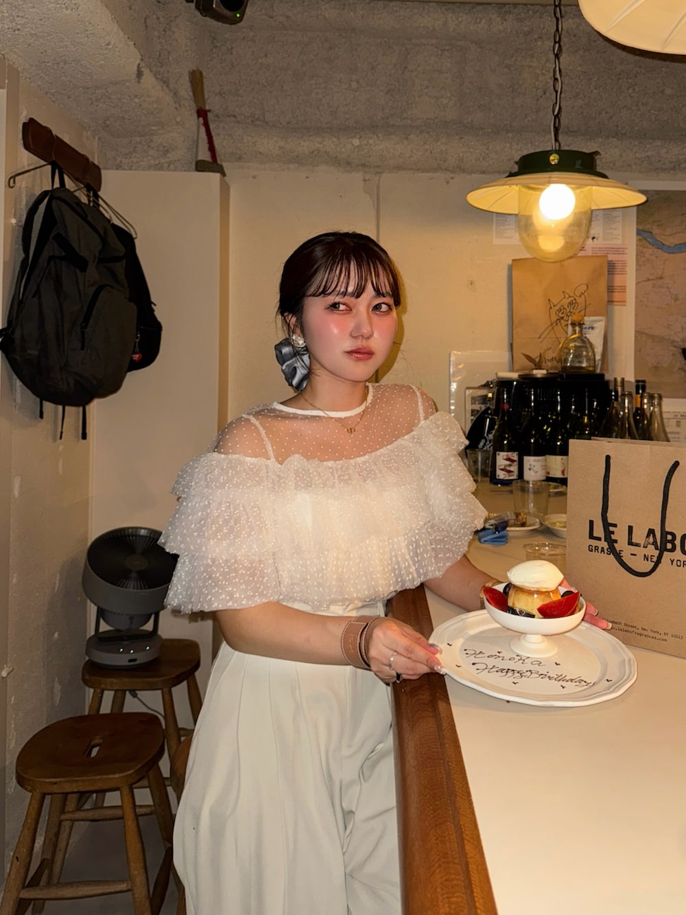 ホワイト系のシャツ/ブラウス、シルバー系のパンプス、ブラック系のハンドバッグを着用したレディースの夏コーディネートの2枚目の写真