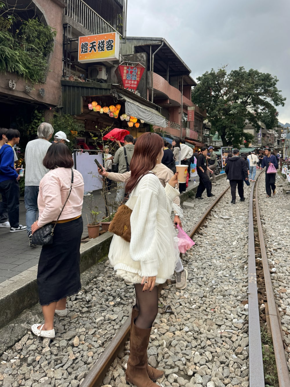 ブラウン系のブーツ、ホワイト系のカーディガン/ボレロを着用したレディースの冬コーディネートの2枚目の写真