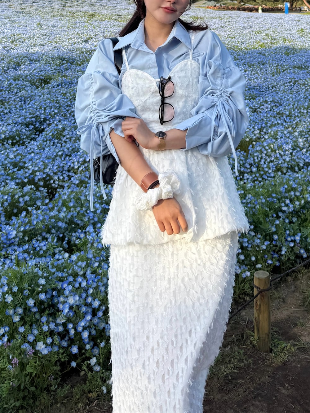 ホワイト系のTシャツ/カットソー、ホワイト系のスカート、ホワイト系のスニーカーを着用したレディースの春コーディネートの3枚目の写真