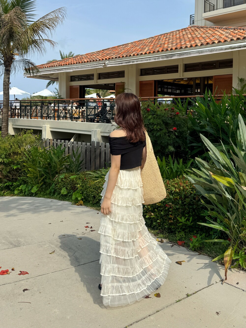 ホワイト系のスカート、ブラック系のトップスを着用したレディースの春コーディネートの3枚目の写真