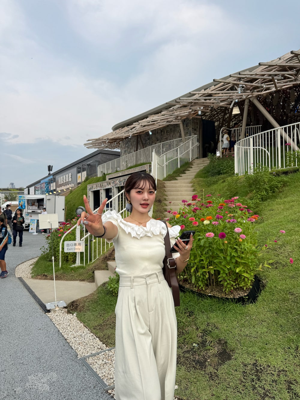 ブラウン系のサンダル、ホワイト系のニット/セーター、ブラウン系のショルダーバッグを着用したレディースの夏コーディネートの3枚目の写真