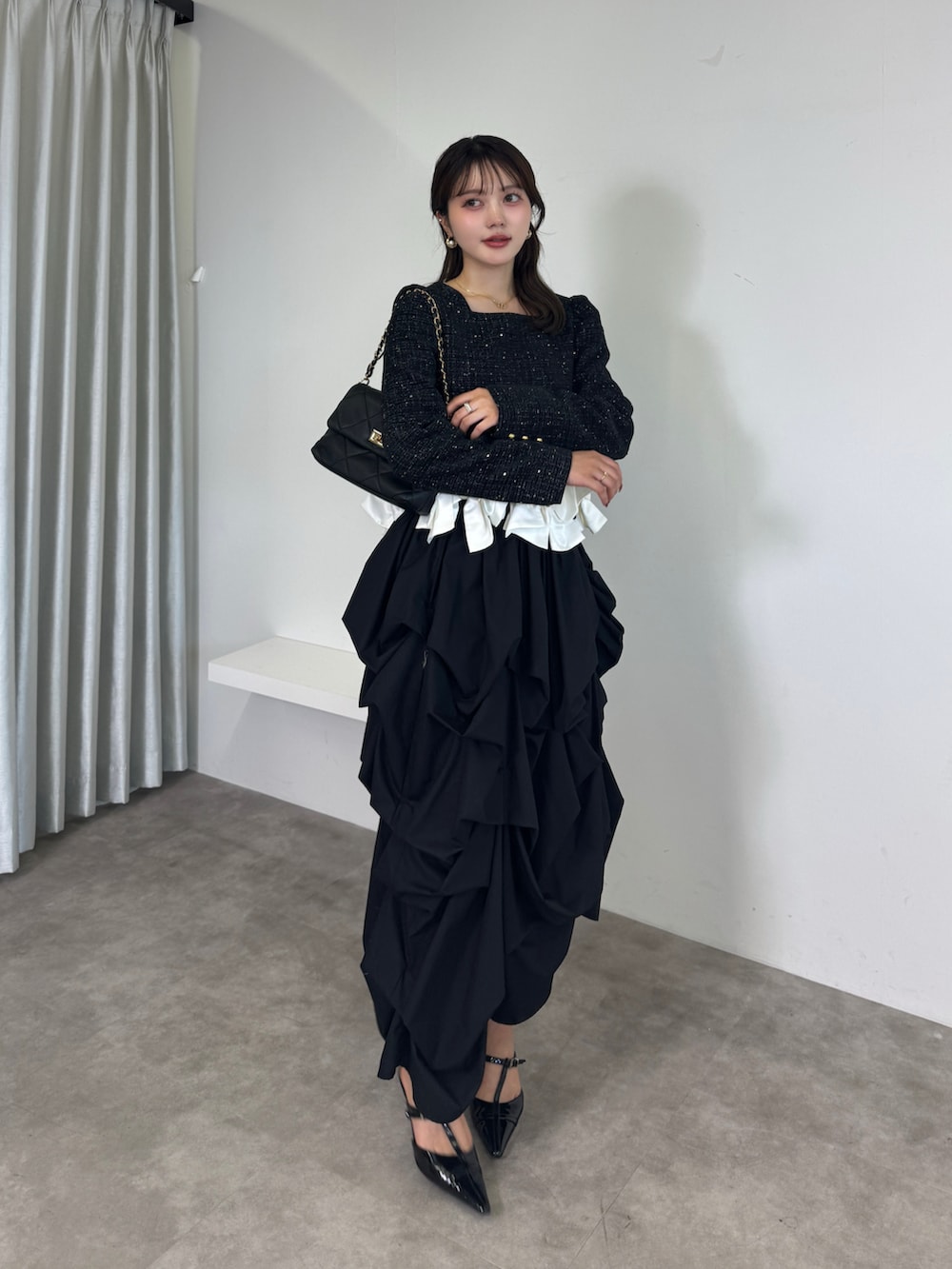 ブラック系のシャツ/ブラウス、ブラック系のスカート、ブラック系のサンダルを着用したレディースの夏コーディネートの2枚目の写真