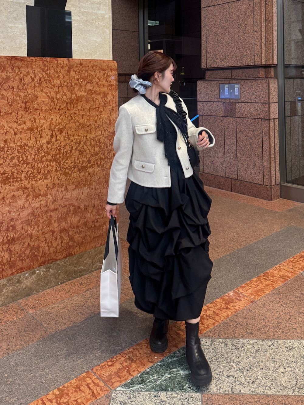 ブラック系のスカート、ピンク系のノーカラージャケット、ブラック系のシャツ/ブラウスを着用したレディースの秋コーディネートの3枚目の写真