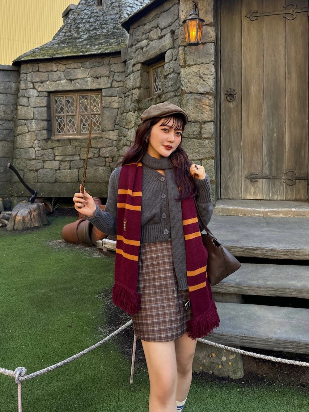 グレー系のニット/セーター、ブラウン系のスカートを着用したレディースの秋コーディネートの4枚目の写真