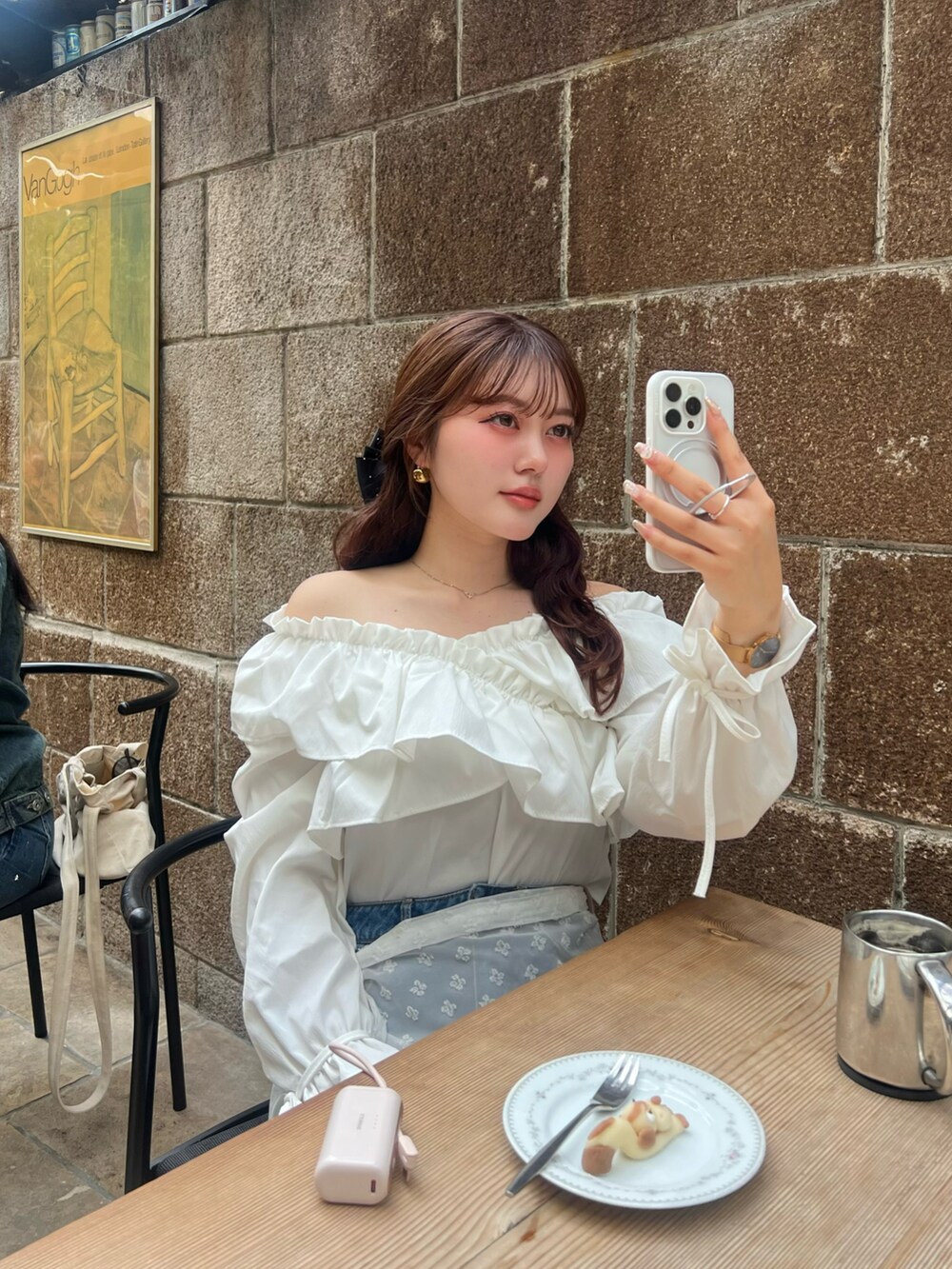 ブルー系のデニムパンツ、ホワイト系のシャツ/ブラウス、ホワイト系のスカートを着用したレディースの春コーディネートの3枚目の写真