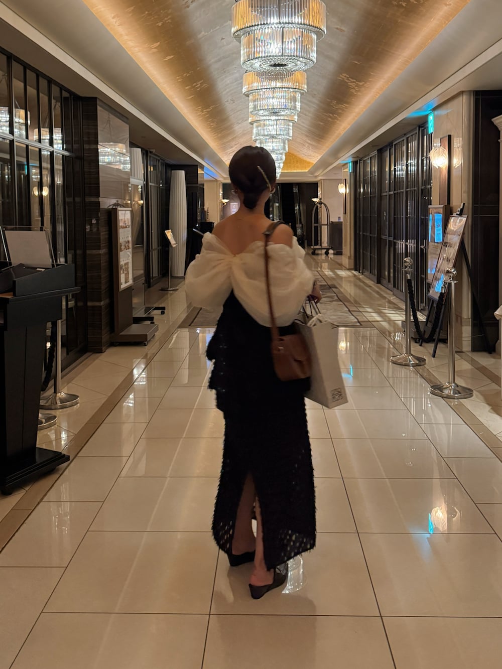 ホワイト系のシャツ/ブラウス、ブラック系のパンプスを着用したレディースの夏コーディネートの2枚目の写真